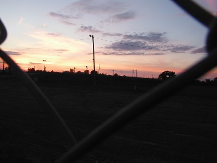 Beyond the chain link fence where I work a cosmic sunset dwarfs my workplace - Jan. 13, 2013